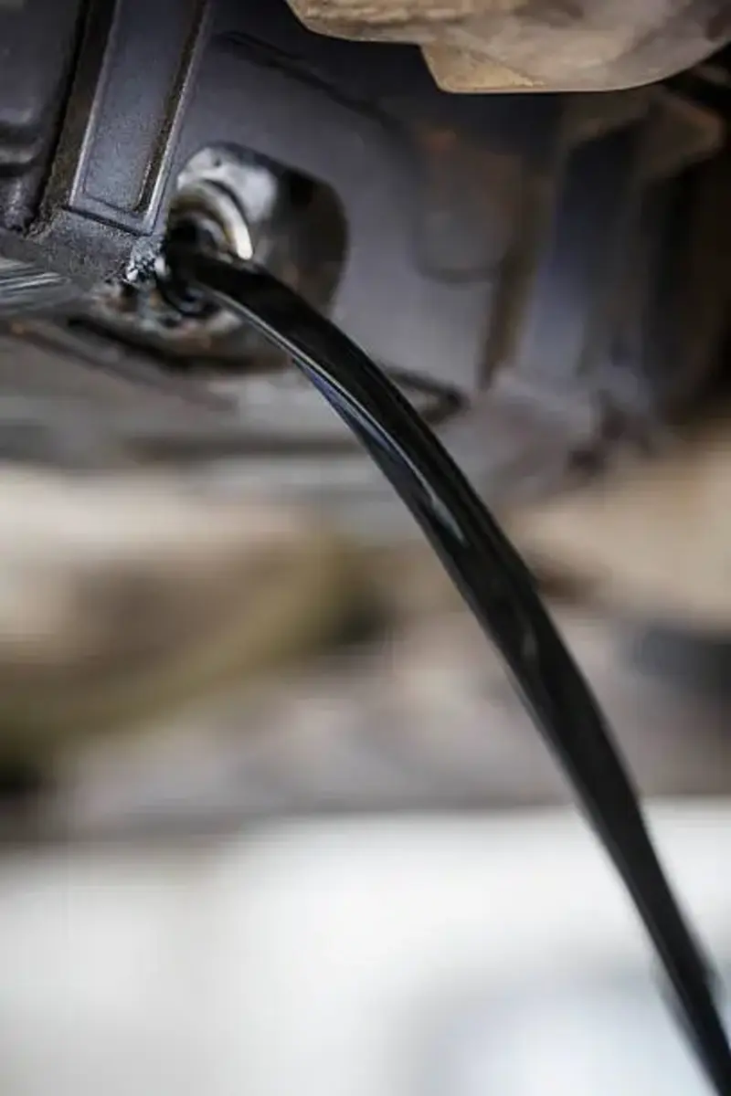 Fleetway mobile mechanic technician showing very dirty old oil from a heavy duty truck oil change.  