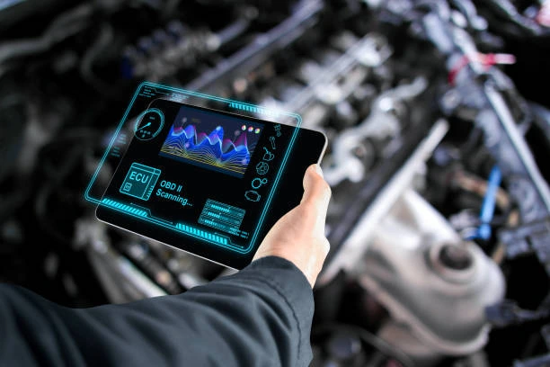Diesel mechanic using a handheld diagnostic scanner to check vehicle performance in Clinton, UT.