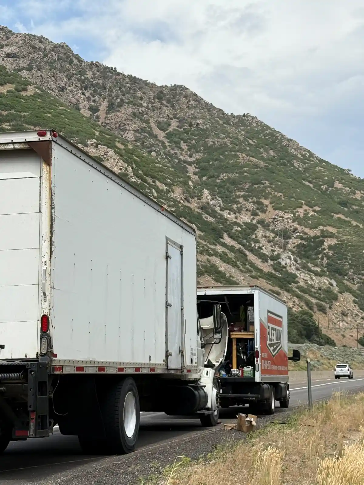 Fleetway Service & Repair performing roadside mobile truck repair for a box truck along a Northern Utah highway, providing on-site diagnostics and heavy-duty repair services.