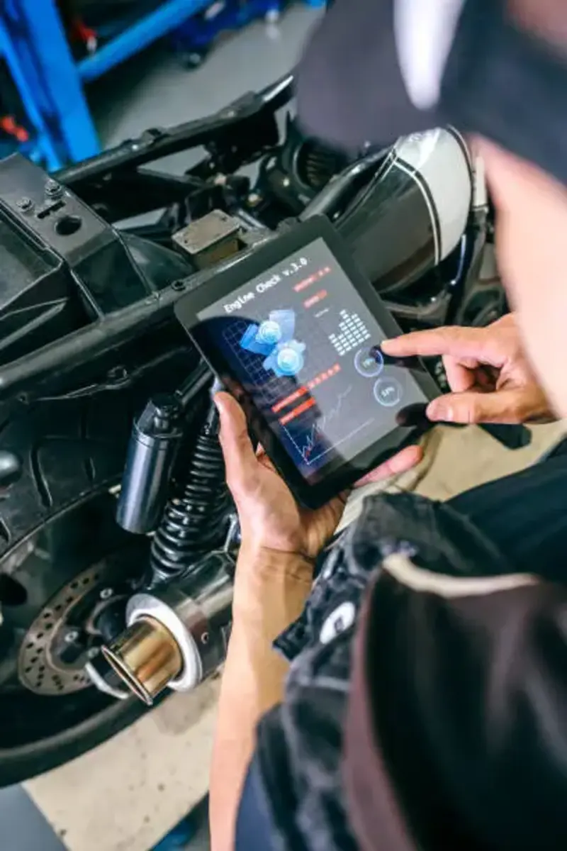 timing-belt-diagnostic-tablet-inspection-clinton-utah. Technician using a diagnostic tablet to inspect engine timing chain performance during preventative maintenance service in Clinton, Utah.